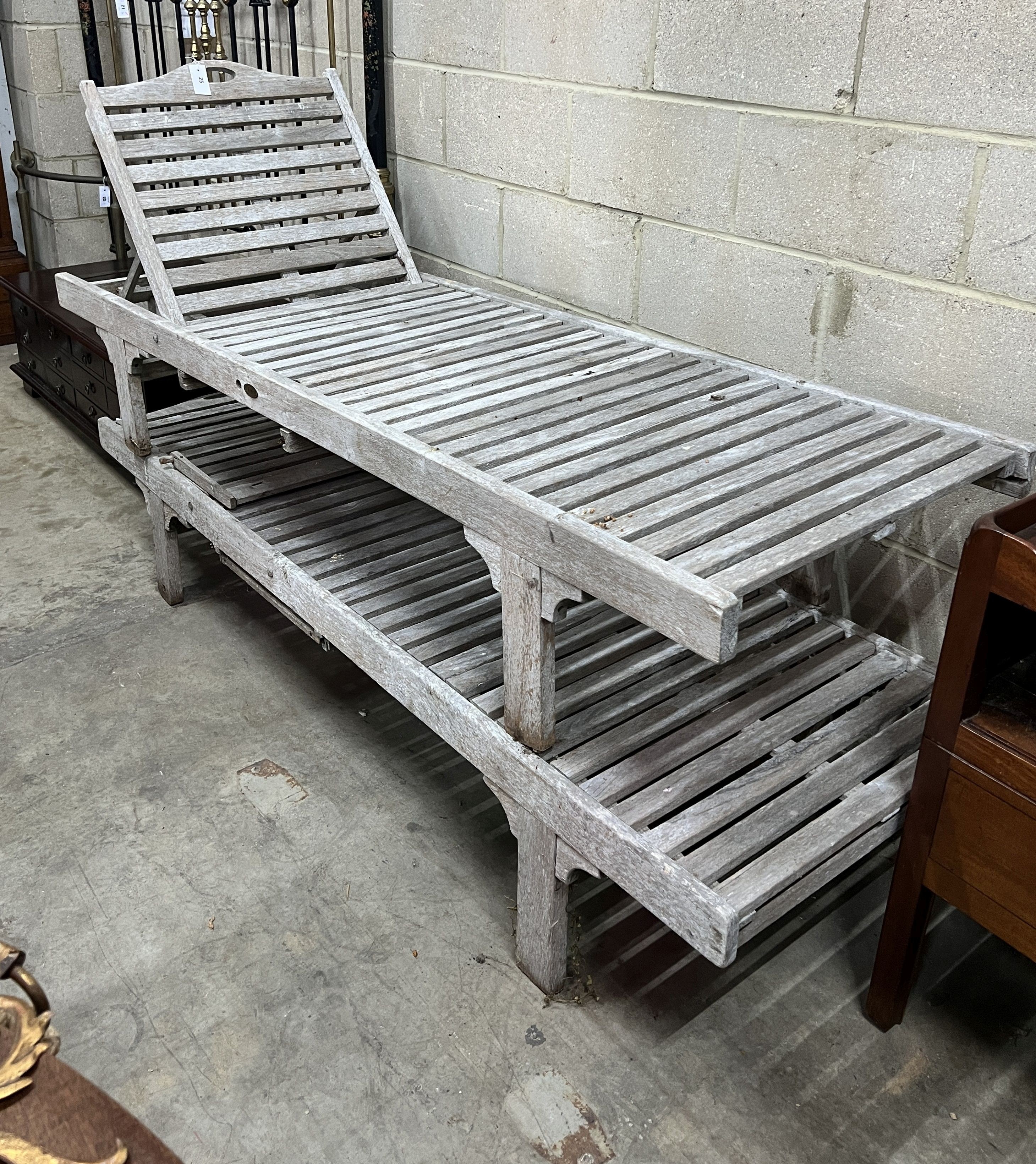 A pair of weathered teak garden loungers